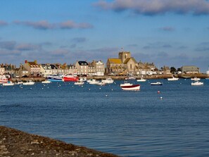 A harbor with various boats docked and a historic building with a tower in the background.