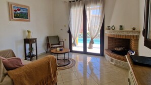 A living room with a sofa, armchair, and a fireplace. - Villa Sellia-Julie (Sellia)