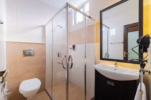 A modern bathroom with a glass shower enclosure, a white sink, and a large mirror. - Auro Bliss - An Opulent 3bhk Penthouse in Dehradun (Dehradun)