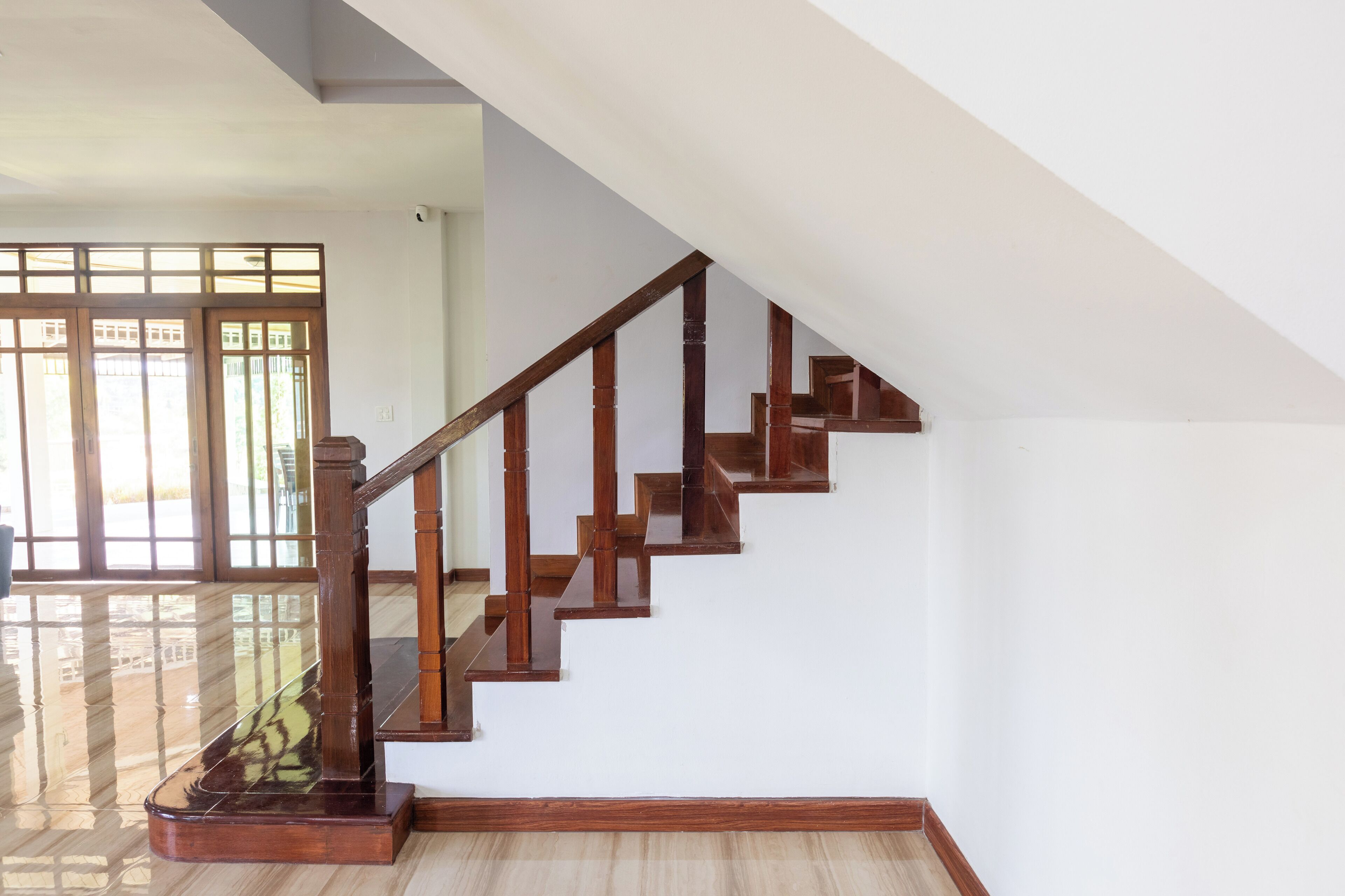A wooden staircase with a glass railing leading to an upper floor.