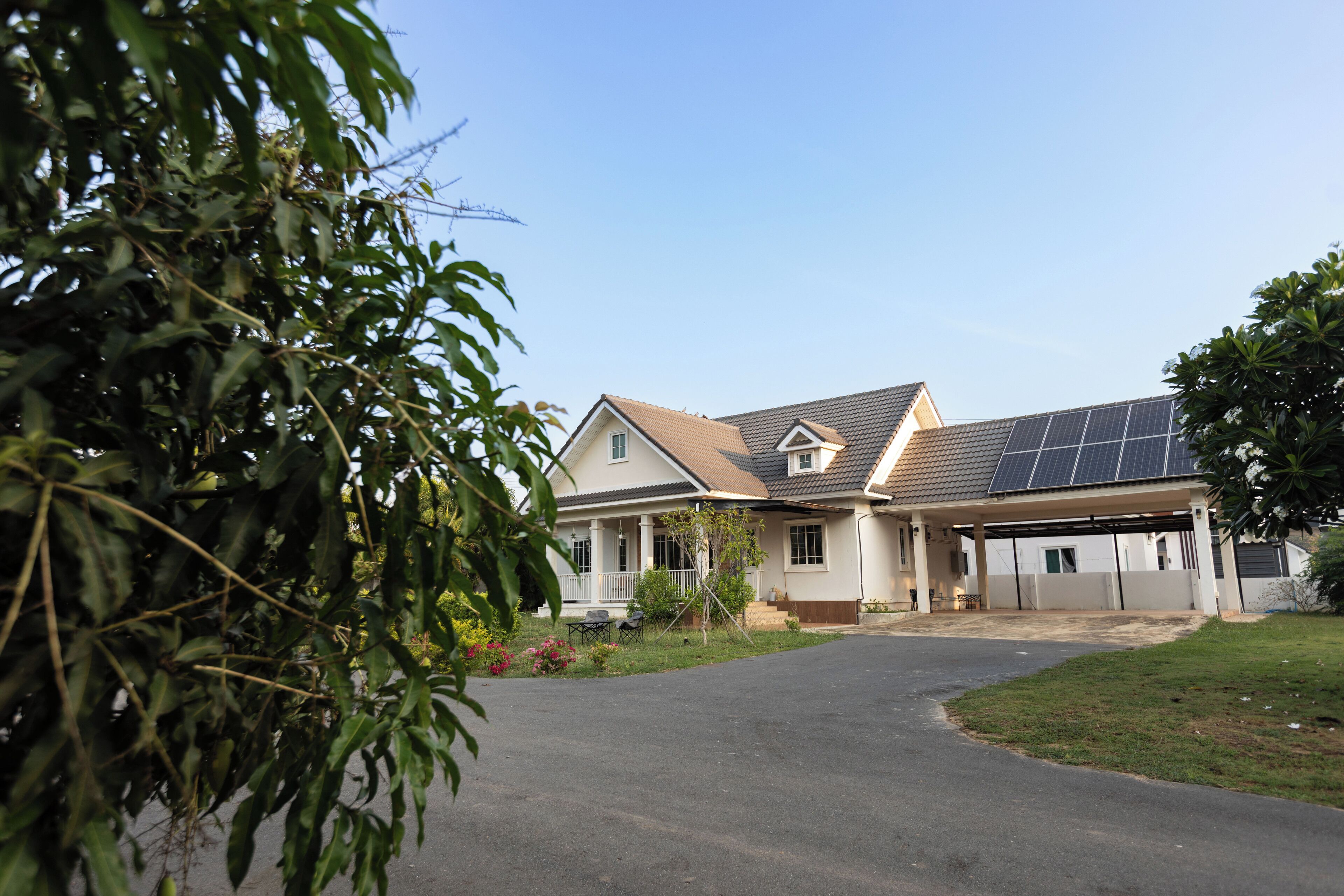 A residential house with a driveway, a covered garage, and solar panels on the roof.