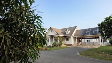 A residential house with a driveway, a covered garage, and solar panels on the roof.
