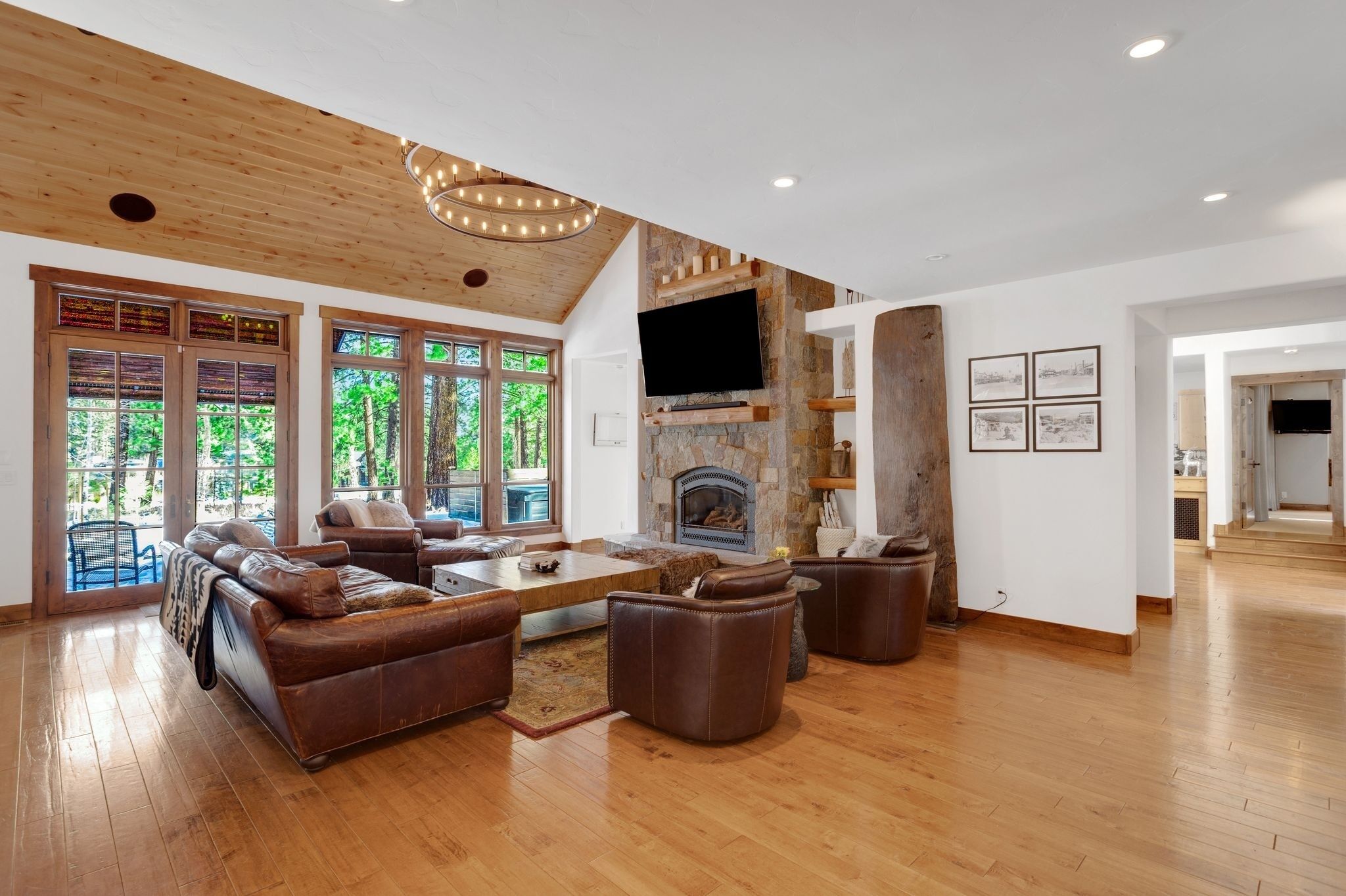A spacious living room with a fireplace, leather sofas, and large windows.
