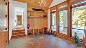 A wooden interior with a stone floor, a bench, and a small Christmas tree.