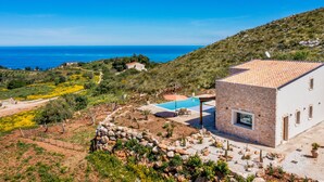 A modern villa with a swimming pool, surrounded by a landscaped garden and overlooking a coastal view. - Villa sulla Roccia, privacy e relax. (Sicilia)