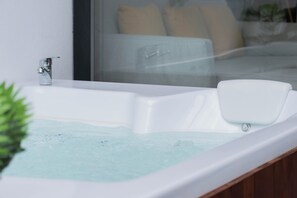 Et moderne badeværelse med et hvidt badekar, en kromarmatur og en glasbrusekabine.