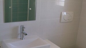 A bathroom with a white sink, a mirror, and a toilet. - Charming studio with balcony, WiFifree parking and AC in adorable old town Brseč (Brsec)