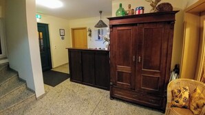 Un vestíbulo con un aparador de madera, un banco y una escalera.