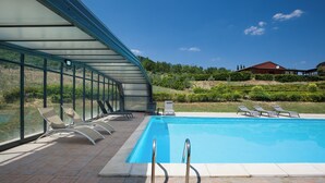 A swimming pool with lounge chairs and a glass-enclosed patio area. - Country House Abate Pool Ac Wifi Potenza (Trivigno)