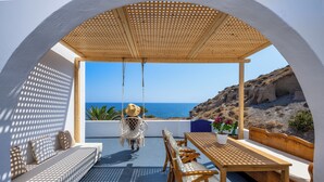 Um pátio ensolarado com mesa e cadeiras de madeira, e um balanço.