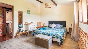 A bedroom with a bed, bedside tables, a dresser, a chair, and a wooden bench. - Gite "La maison de la colline" 5 minutes de Tournus Sud Bourgogne (Vers)