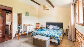 A bedroom with a bed, bedside tables, a dresser, a chair, and a wooden bench.