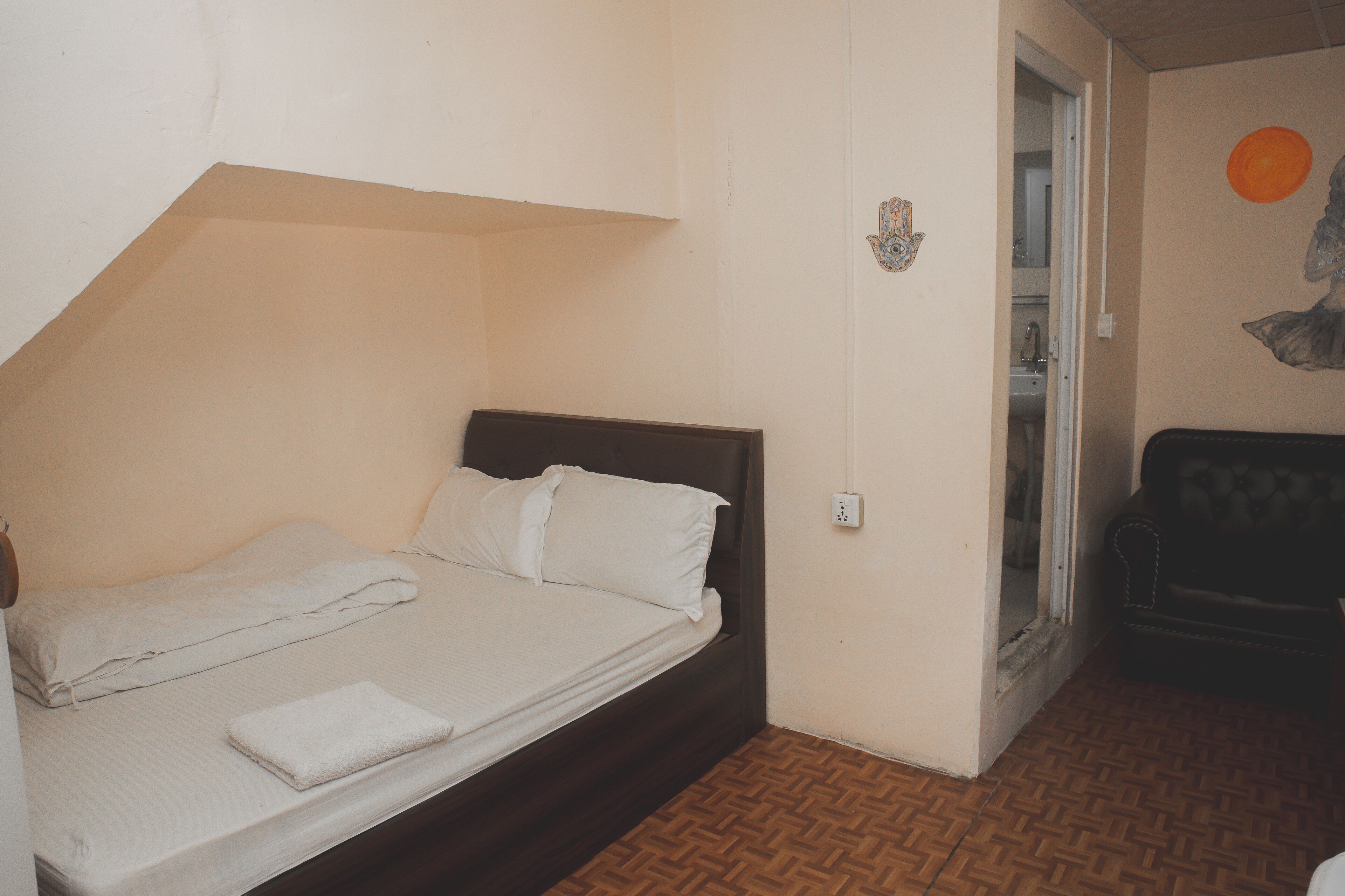 Un dormitorio con una cama individual, una mesita pequeña y una silla.
