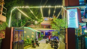 A hostel entrance with a gated driveway, motorcycles parked, and a sign for Gypsy Hostel & Backpackers. - Gypsy hostel & Backpackers (Pokhara)