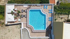 Una piscina al aire libre de temporada, sillones reclinables de piscina