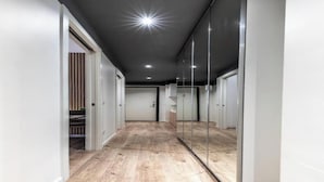 A hallway with wooden flooring, white walls, and a glass partition on one side. - Elegant & Spacious 3-Bedroom Apartment in Milan’s Historic Center (Milano)