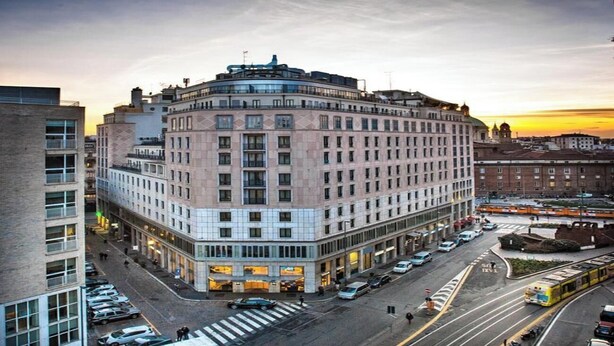 A multi-story hotel with a corner location, featuring a prominent entrance and a large parking lot. - Elegant & Spacious 3-Bedroom Apartment in Milan’s Historic Center (Milano)