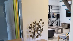 Un soggiorno moderno con un mobile in legno, una pianta decorativa in metallo e una scala.