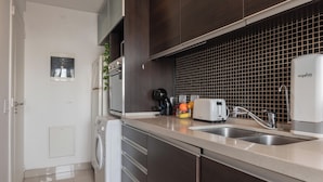A modern kitchen with a washing machine, a coffee maker, and a toaster. - MOT LIVE HOTEL (Buenos Aires)