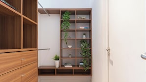 A wooden bookshelf with multiple shelves, some containing books and others with decorative items and plants. - MOT LIVE HOTEL (Buenos Aires)