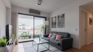 A modern living room with a sofa, coffee table, and potted plants. - MOT LIVE HOTEL (Buenos Aires)