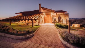 A modern house with a brick pathway leading to a wooden pergola and a stone entrance. - Lavandas de Cunha Pousada Boutique (Cunha)