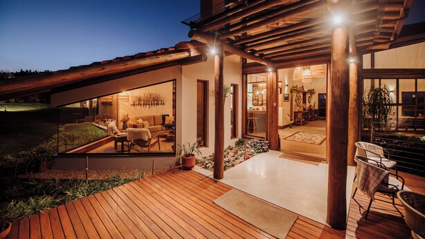 A modern house with a wooden deck, large windows, and a covered outdoor area. - Lavandas de Cunha Pousada Boutique (Cunha)
