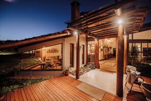 A modern house with a wooden deck, large windows, and a covered outdoor area. - Lavandas de Cunha Pousada Boutique (Cunha)