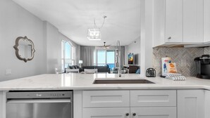A modern kitchen with white cabinetry, a dishwasher, and a large island. - 🏝️Huge Balcony w/Gulf Views ☀️ Beach Colony Resort East 11A (Navarre Beach)