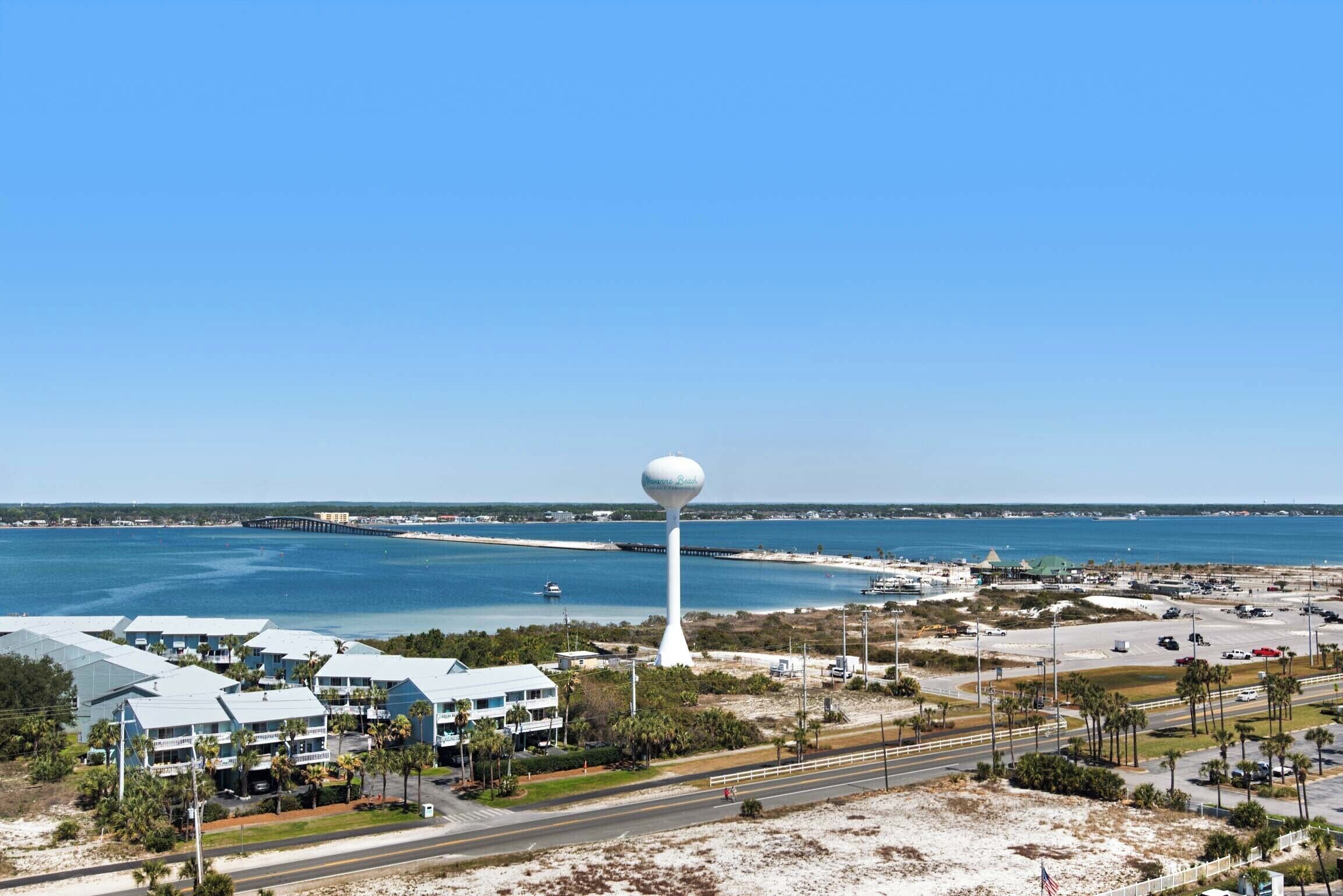 Ein Hotel an der Küste mit einem markanten Wasserturm, Blick auf den Strand und mehreren Gebäuden mit flachen Dächern.