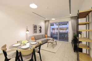 Un salon moderne comprenant un coin repas, un canapé, une table basse et une bibliothèque.