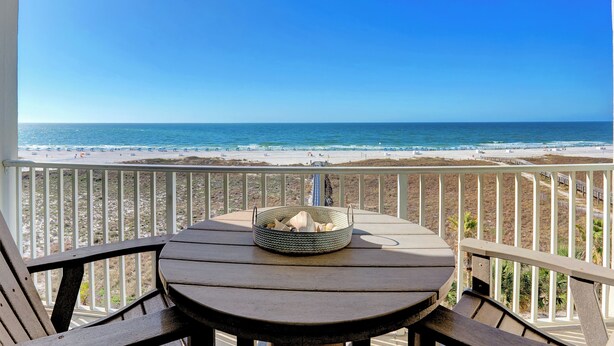 Un balcon avec vue sur la plage et l’océan.