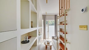 Ein modernes Interieur mit einer Holztreppe, weißen Wänden und einer Glastür, die nach draußen führt.