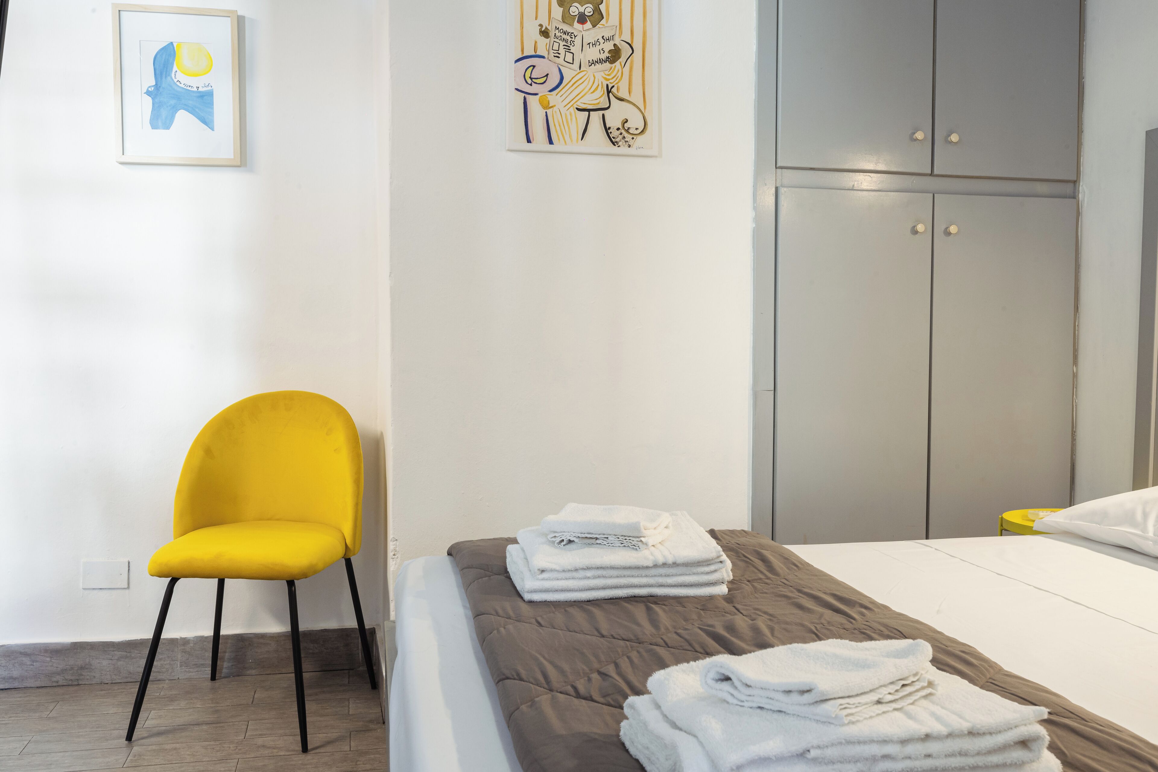 Um quarto com uma cama, uma cadeira e um guarda-roupa.