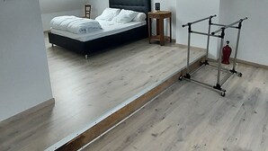 Ein Schlafzimmer mit einem Bett, einem kleinen Tisch, einem Stuhl und einem Deckenventilator.