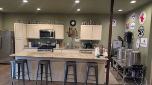 Una cocina con encimera de granito, electrodomésticos de acero inoxidable y una zona de bar con taburetes.