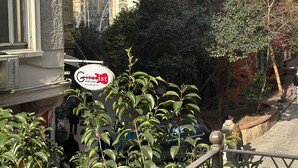 Vista da rua com uma placa indicando um restaurante chamado "Citarist" e um carro estacionado.