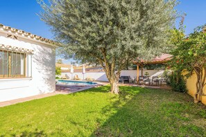 A backyard with a swimming pool, a pergola, and outdoor furniture. - Villa Bart (Estepona)