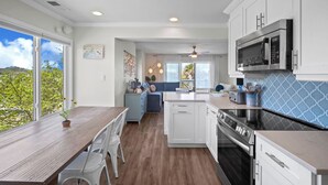 A modern kitchen with white cabinets, a built-in oven, and a microwave. - Ocean View Condo, Golf Cart Included, Private Patio, Newly Redecorated - 607 Newhaven (Fripp Island)