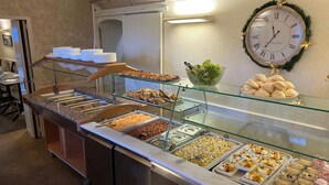 Ein reichhaltiges Buffet mit verschiedenen Speisen, einer Uhr und einem Weihnachtsgesteck.