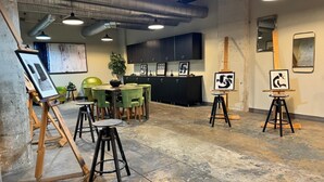 An art gallery with paintings on easels, a reception desk, and a seating area with chairs and tables. - Urban Style 2 BR | 2 Bath | Downtown | Free Valet Parking | 5 (Dallas)