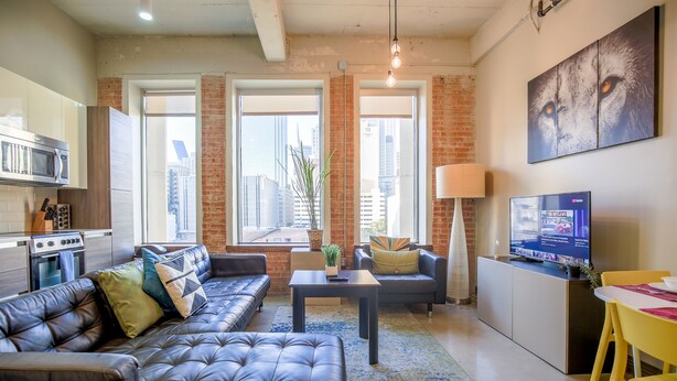 A modern living room with a sofa, coffee table, and a TV. - Urban Style 2 BR | 2 Bath | Downtown | Free Valet Parking | 5 (Dallas)