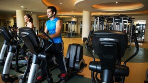 A gym with treadmills, weight machines, and a curved ceiling design. - Grand Master Suite at Luxury 5-Star Resort in Cabo San Lucas Mexico (Cabo San Lucas)