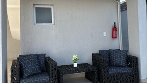 Un área de descanso con dos sofás y una mesita, un extintor y una ventana en la pared.