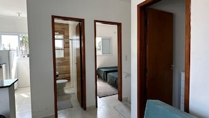Un amplio espacio de sala con sofá, zona de cocina y vistas al exterior.