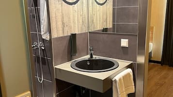 Eenpersoonskamer | Badkamer | Een douche, een haardroger, handdoeken, shampoo