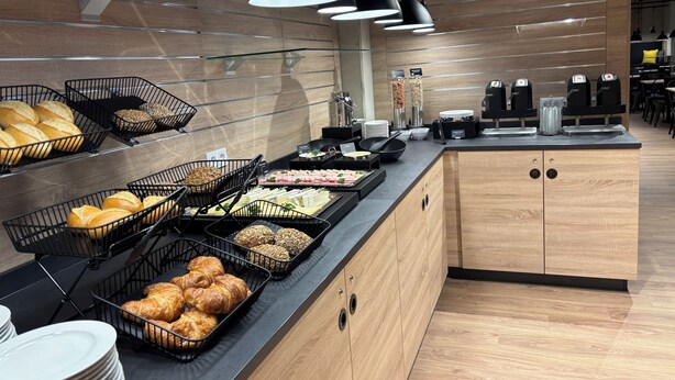 A buffet setup with various food items and coffee machines. - Das Schlafwerk Köln-Messe (Cologne)