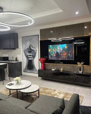 A modern living room with a flat-screen TV, a large abstract painting, and a stylish entertainment unit. - Nesto Homes and Apartment  (Lekki)