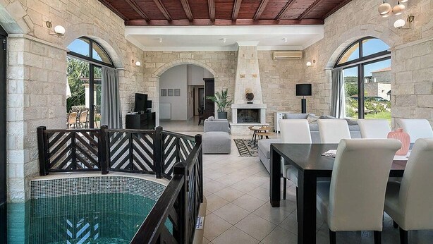 Un amplio espacio interior con piscina, asientos y chimenea.
