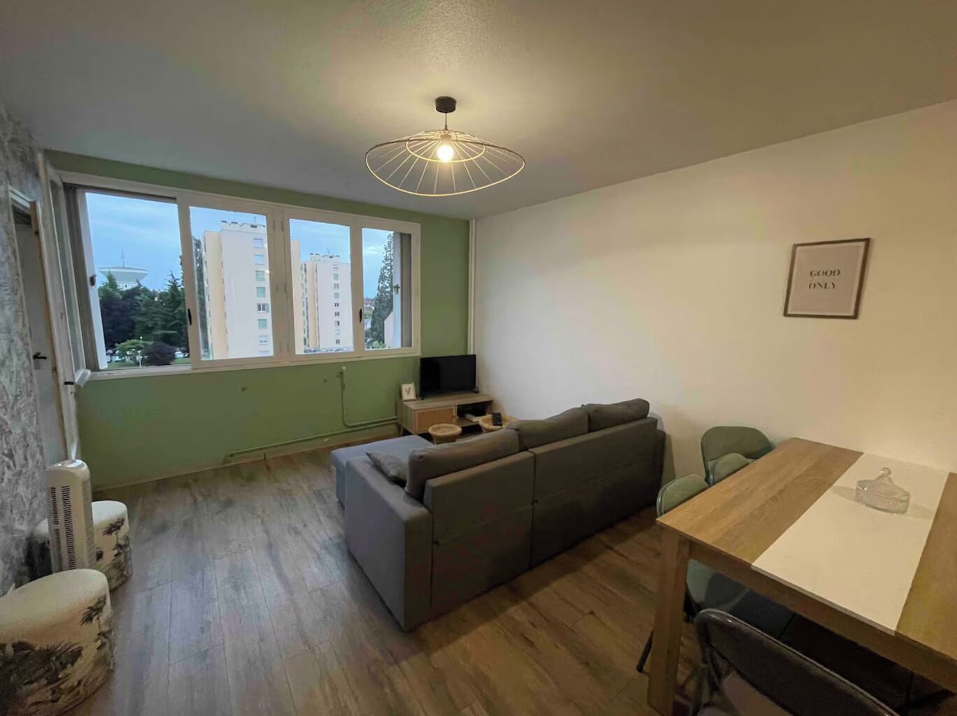 A modern living room with a sofa, a TV, and a dining table.
